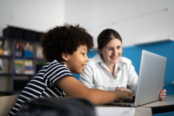 istock Teacher and student using a laptop in the classroom 1367328145