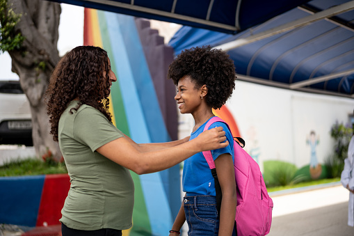 Mother talking to her daughter in front of school