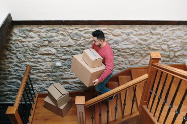 istock Young man carrying cardboard boxes for moving 1367328466