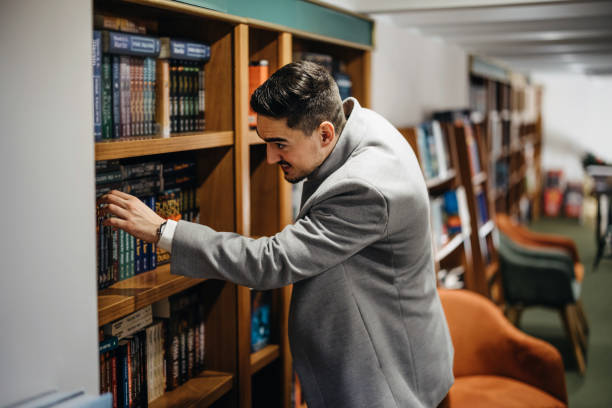 istock Middle age man choosing and reading books in modern bookstore. 1367328479