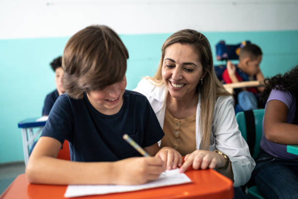 istock Teacher helping a student with a lesson in the classroom 1367329386