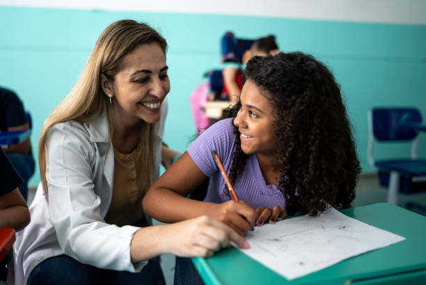istock Teacher helping a student with a lesson in the classroom 1367329460
