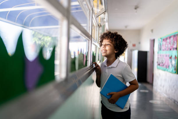 Boy looking through the window at school