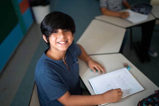 istock Portrait of a boy taking notes in the classroom 1367329647