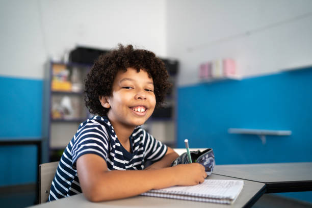 istock Portrait of a boy taking notes in the classroom 1367329738