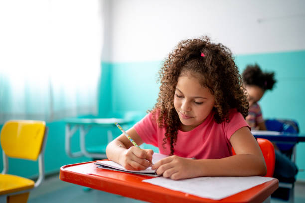 教室でメモを取る女の子 - school supplies child back to school book ストックフォトと画像