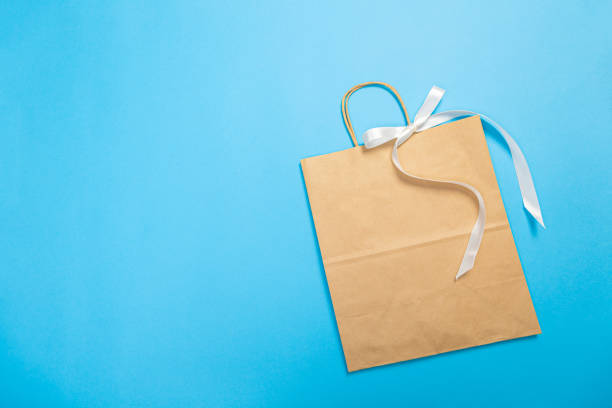 istock Paper bag for shopping on a blue background. Logo layout 1367330726