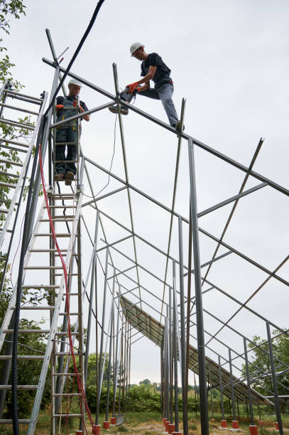 istock Male workers installing metal poles and rails for solar panels. 1367331403
