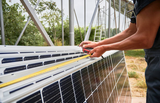istock Male worker measuring solar panels with tape measure. 1367331471