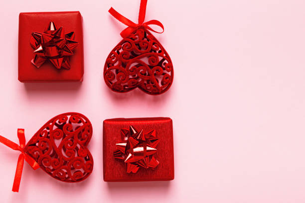istock Red Valentine hearts and gift boxes on a pink background with copy space. 1367333162