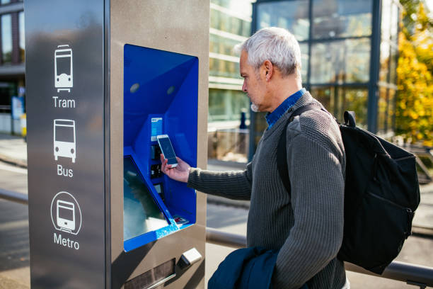 istock Mature businessman purchasing ticket on vending machine 1367336368