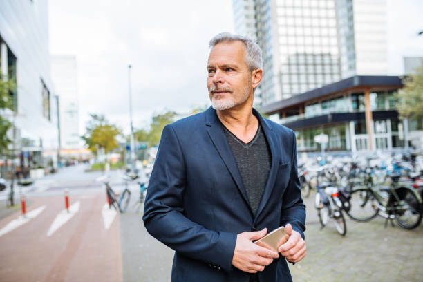 Mature businessman commuting and using smart phone