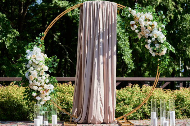 istock Circle wedding arch decorated with white, pink flowers and greenery outdoors, copy space. Wedding setting on back yard. Floral composition 1367337619