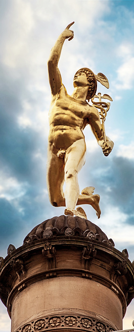 Stuttgart, Germany - Famous landmark: golden Hermes statue on a column near Schlossplatz against a blue sky