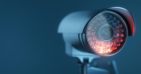 Security camera with infrared light on a dark blue background with a copy space