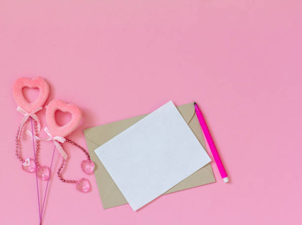 istock a mock-up of an empty greeting card and two hearts on a pink background. 1367340731