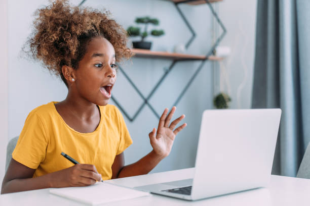 istock Schoolgirl studying with video online lesson at home. 1367342104