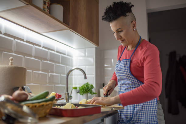 istock Woman cutting vegetables at the kitchen 1367342118