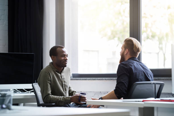 istock Two young male colleagues speaking to each other 1367343807
