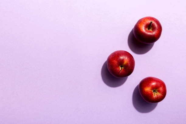 istock Many red apples on colored background, top view. Autumn pattern with fresh apple above view with copy space for design or text 1367343969