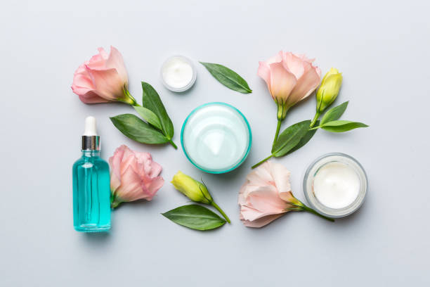 istock Composition with cosmetic products and beautiful roses on color background. Flat lay 1367344040