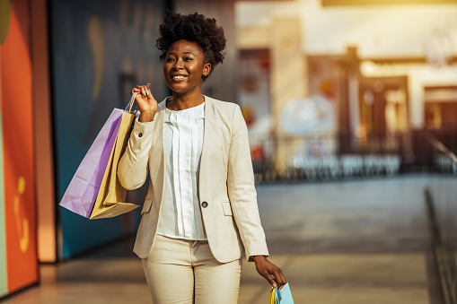Happy shopping woman holding bags and walking at the mall - lifestyle concepts
