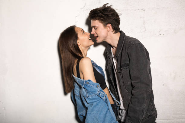 Hipster loving couple eating chocolate. Picture of young hipster loving couple standing over gray background eating chocolate. couple on bad date stock pictures, royalty-free photos & images