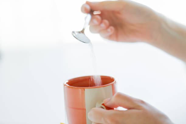 istock close up of woman hands adding sugar to tea cup 1367346168