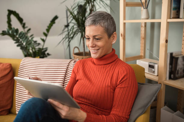 istock Young woman relaxing at home and shopping online using digital tablet 1367346718