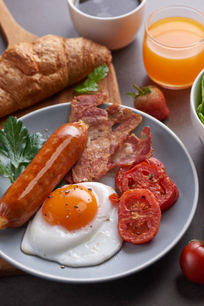 istock Delicious breakfast with fresh croissants, fried eggs with bacon and coffee served, orange juice. strawberry, butterhead, blackberry salad. full american breakfast top view. 1367348788
