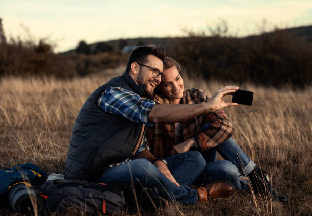istock Couple sitting on grass during sunset resting after hiking. 1367348923