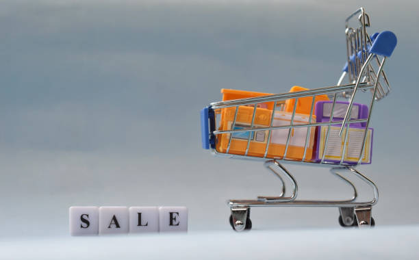 istock Shopping cart replica with items filled in it over sky background. 1367351788
