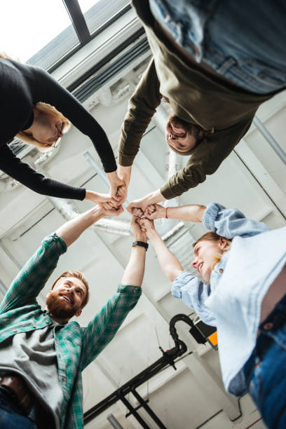 istock Colleagues in office holding hands of each other 1367356285