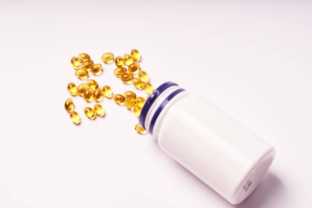 istock White bottle with scattered vitamins on white background 1367356769