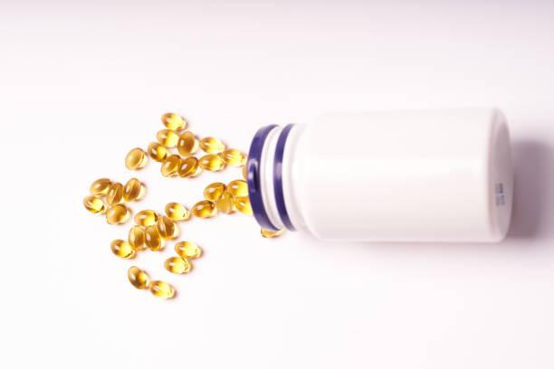 istock White bottle with scattered vitamins on white background 1367356774