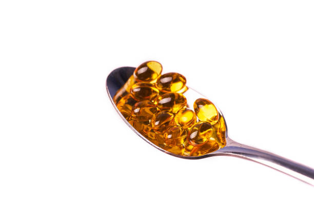 istock Capsules with vitamin in a teaspoon on a white background 1367356789