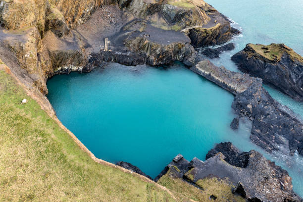 vue aérienne d’une côte rocheuse et d’un lagon dans le pembrokeshire, pays de galles (blue lagoon, abereiddy) - wales south wales coastline cliff photos et images de collection