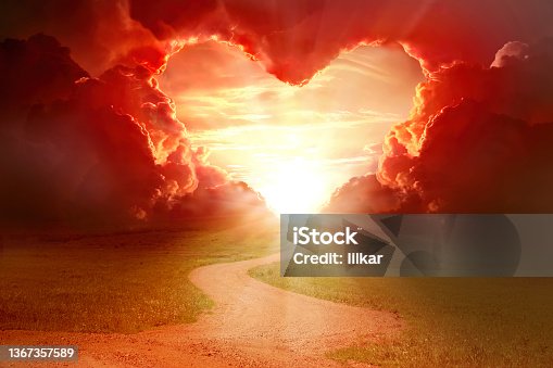 istock Red heart shaped sky at sunset. Beautiful landscape with flowers.Love background with copy space. Road to love 1367357589