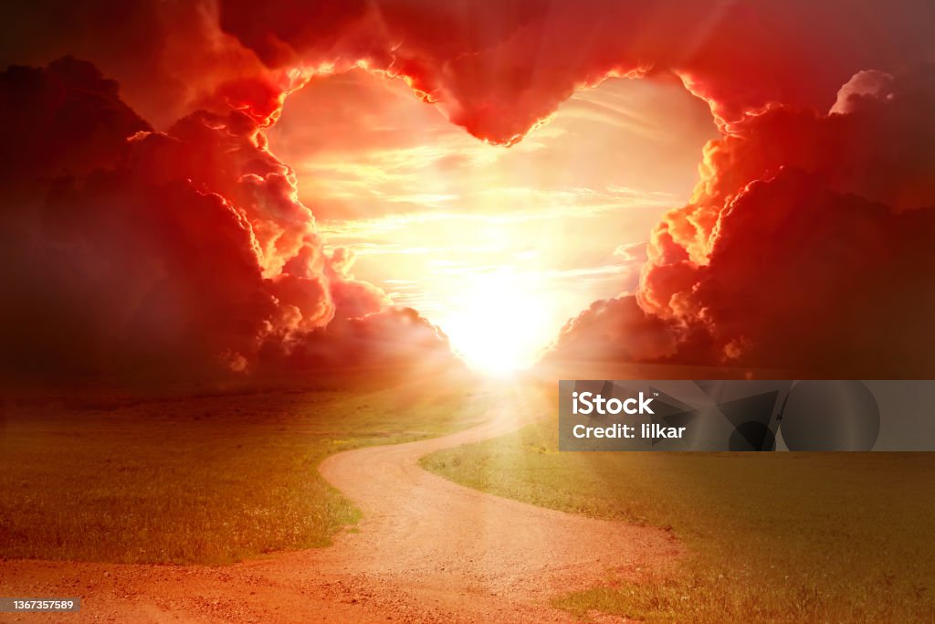 Red heart shaped sky at sunset. Beautiful landscape with flowers.Love background with copy space. Road to love Red heart shaped sky at sunset. Beautiful landscape with road.Love background with copy space. Road to love Love - Emotion Stock Photo