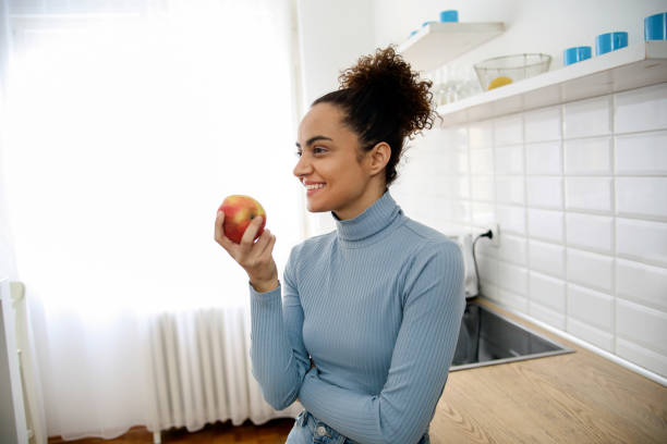 istock Young woman eating an apple 1367357721