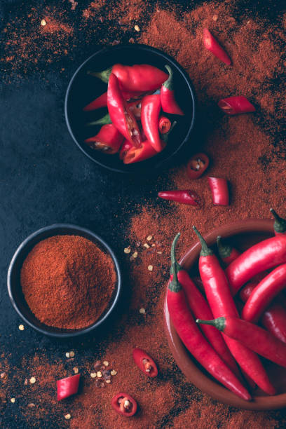 istock Red hot chili pepper background. Ground red cayenne pepper and chopped, rustic style. Spices Asian and Mexican cuisine 1367359468