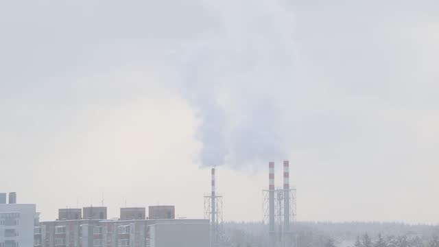 On a cloudy winter day, smoke comes from the chimney. Global pollution of the planet.
