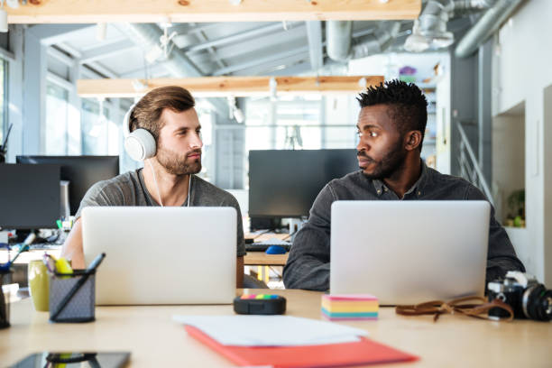 istock Young serious colleagues sitting in office coworking 1367361317