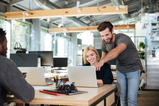 istock Cheerful young colleagues sitting in office coworking 1367361579