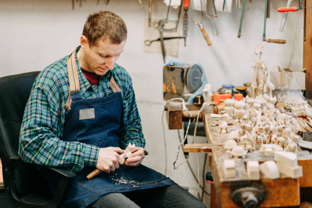 istock Craftsman shaping wood into small souvenir 1367362005