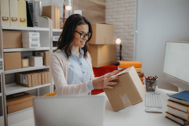 Woman packs the books for delivery Beautiful young  business owner woman prepare parcel box and check online orders of product for deliver to customer. Shopping Online concept. book bookstore sale shopping stock pictures, royalty-free photos & images