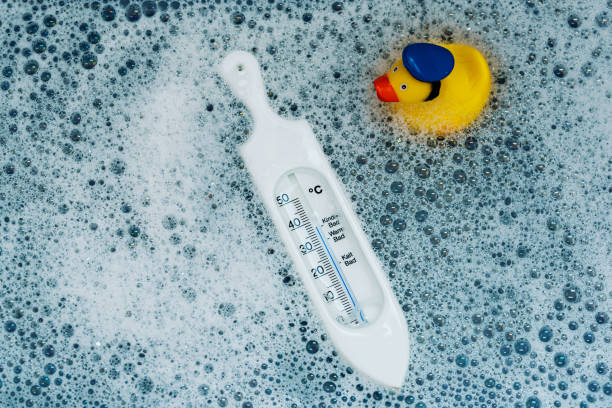 thermometer in baby bath for temberature check stock photo