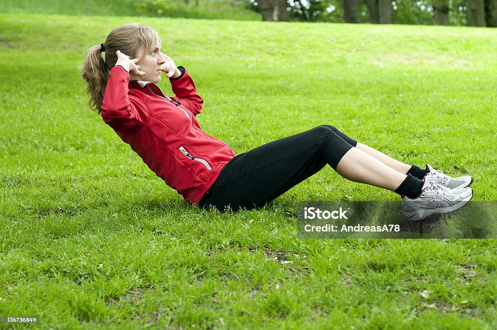 Garota fazendo sit Up em um gramado - Foto de stock de Abdominais royalty-free