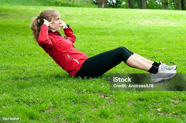 Foto de Garota Fazendo Sit Up Em Um Gramado e mais fotos de stock de Abdominais - Abdominais, Adulto, Cabelo Louro