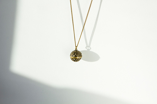 Set of gold chains with pendant on white background close up